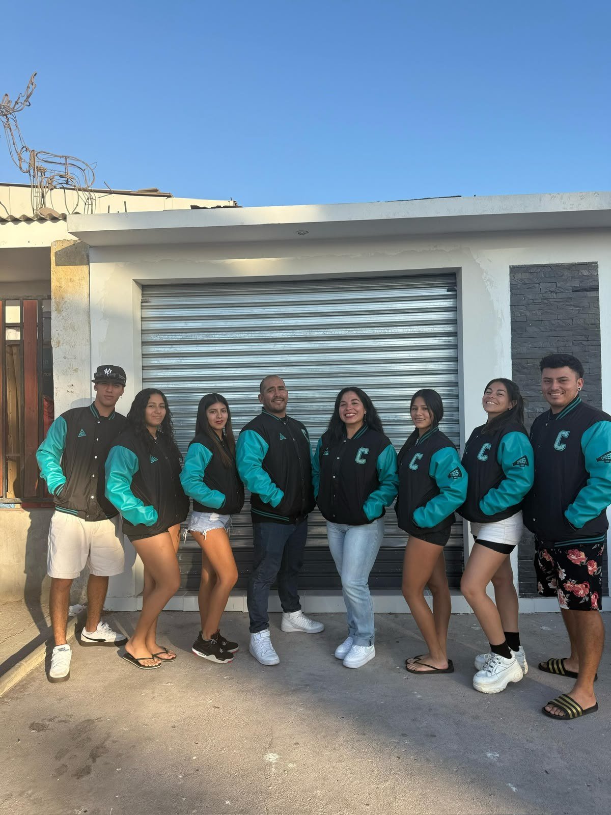 Grupo con chaquetas varsity negras y turquesa
